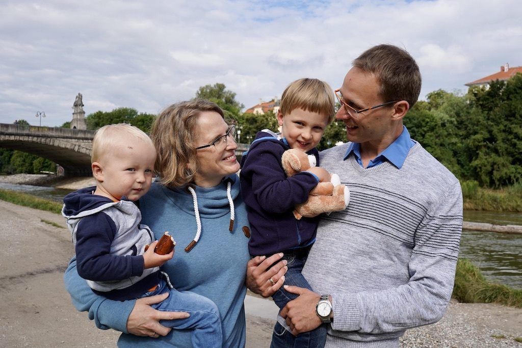 Herzkind Leon mit seinen Eltern und seinem kleinen Bruder an einem Flussufer.