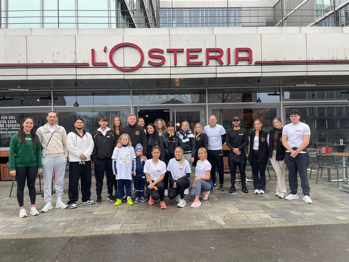 Kinderherzenlauf 2025: Ein L'Osteria-Team steht am Lauftag vor seinem Restaurant.